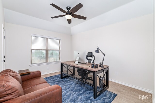 home office with lofted ceiling, hardwood / wood-style flooring, and ceiling fan