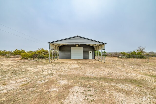 garage featuring a rural view and a carport