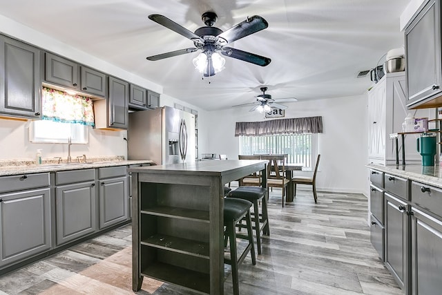 421 N Archer St, San Angelo, TX 76903 - kitchen with gray cabinets, stainless steel fridge, ceiling fan, and healthy amount of natural light