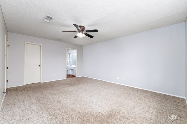 empty room with ceiling fan, carpet flooring, and a textured ceiling