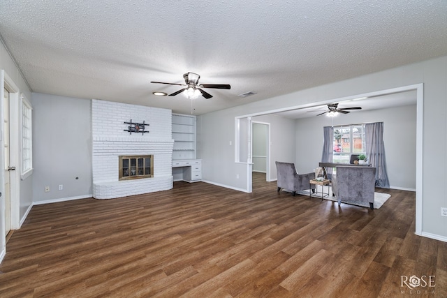 unfurnished living room featuring dark hardwood / wood-style flooring, ceiling fan, a textured ceiling, and a fireplace