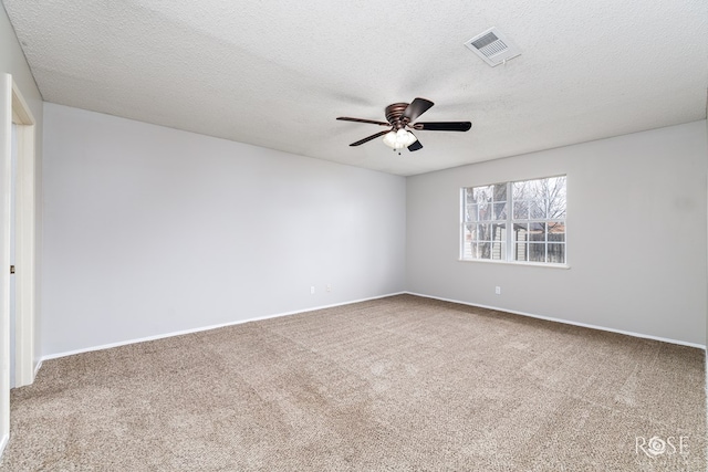 empty room featuring ceiling fan, carpet floors, and a textured ceiling