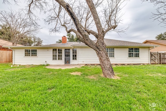 rear view of property featuring a lawn and a patio