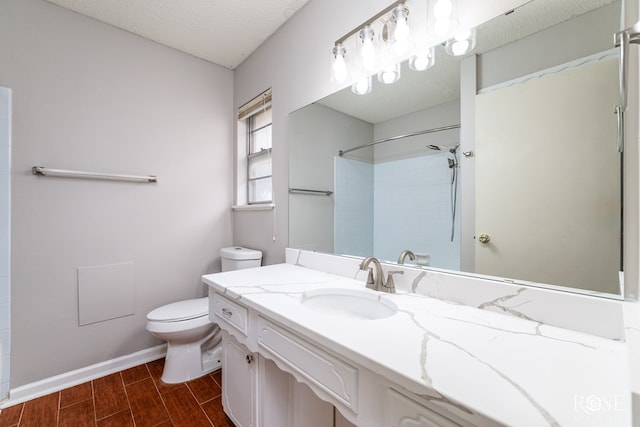 bathroom with a shower, vanity, toilet, and a textured ceiling