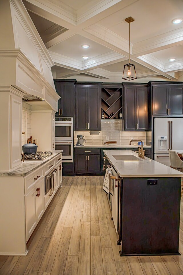 kitchen with sink, double wall oven, stainless steel gas cooktop, white cabinets, and high end refrigerator