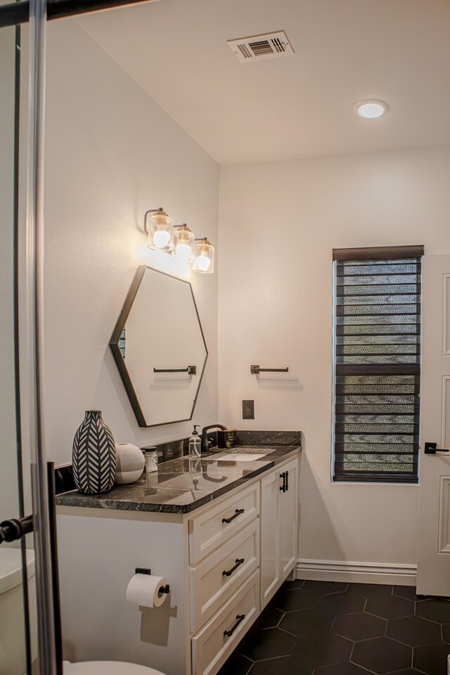 bathroom featuring vanity, toilet, and tile patterned flooring