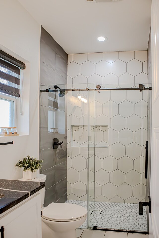 bathroom featuring vanity, walk in shower, and toilet