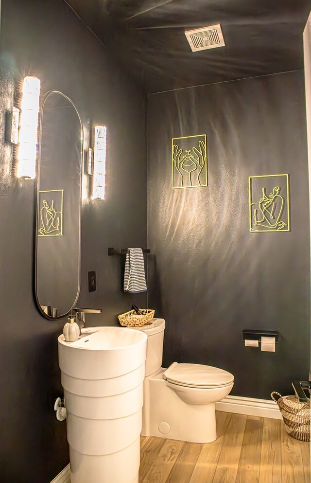 bathroom with wood-type flooring and toilet