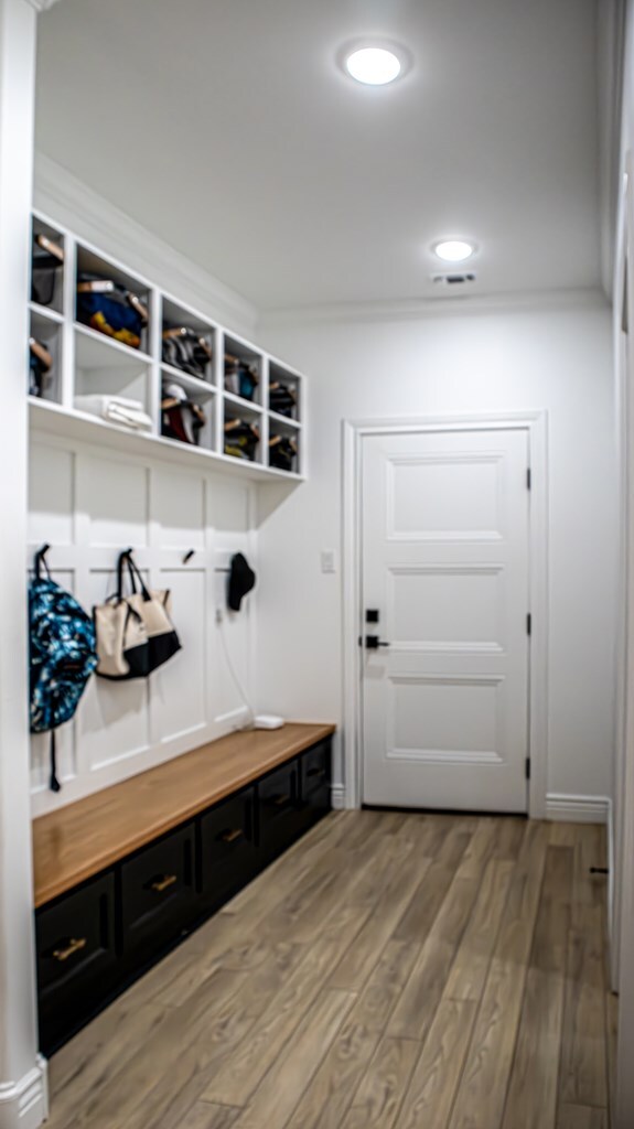 mudroom with crown molding and wood-type flooring