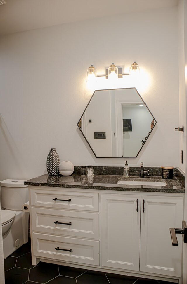 bathroom featuring vanity, tile patterned floors, and toilet