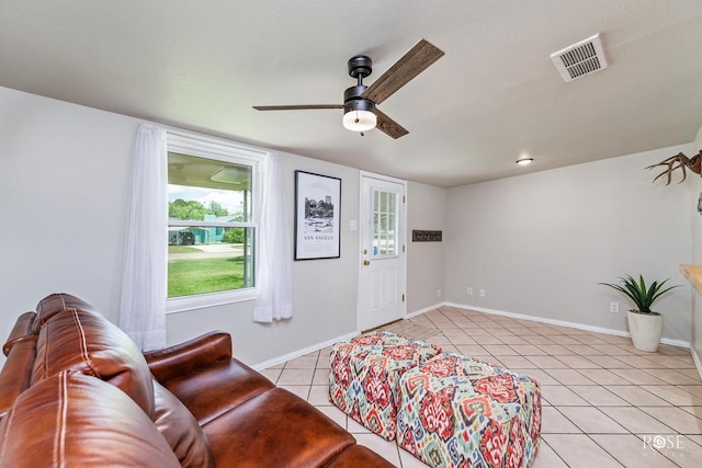 living room featuring visible vents, a ceiling fan, baseboards, and light tile patterned floors