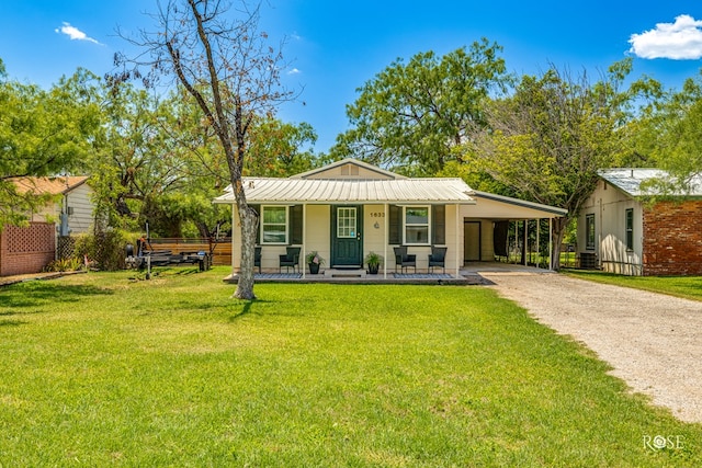 view of front of house with driveway, covered porch, a carport, a front yard, and metal roof