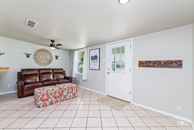 living area featuring baseboards, a ceiling fan, visible vents, and light tile patterned floors