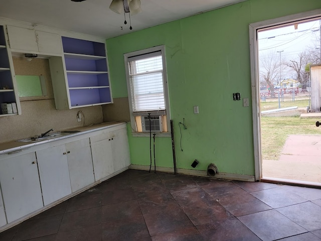 kitchen with white cabinetry, decorative backsplash, sink, and cooling unit