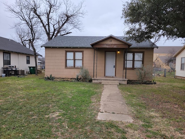 view of front of property with central AC and a front yard