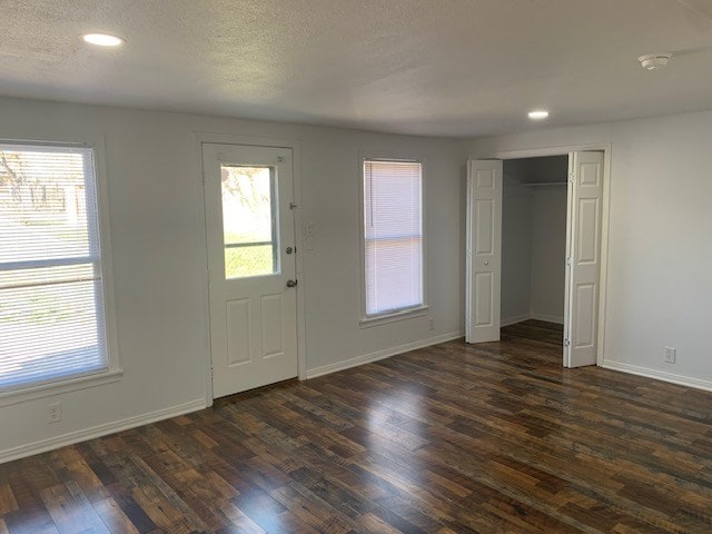 foyer with dark hardwood / wood-style floors and a textured ceiling