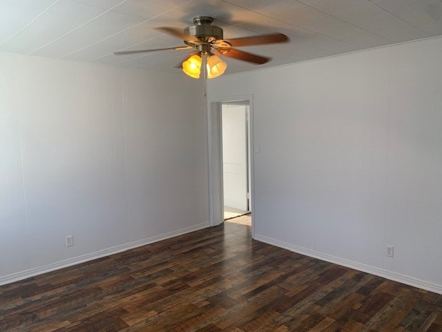 empty room with ceiling fan and dark hardwood / wood-style flooring