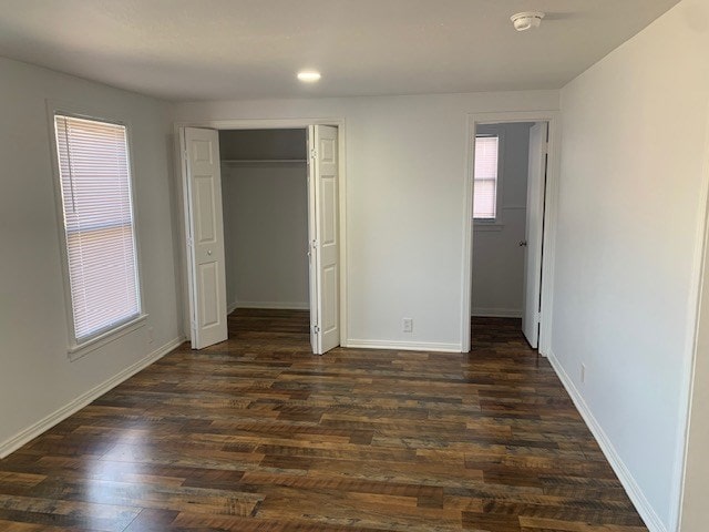 unfurnished bedroom with a closet and dark hardwood / wood-style floors