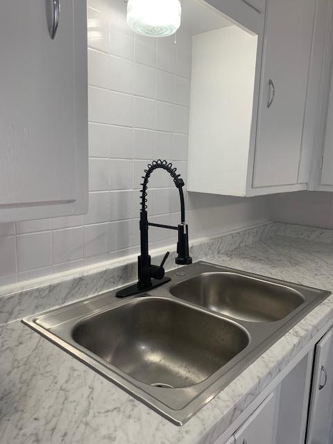 room details featuring sink and white cabinets