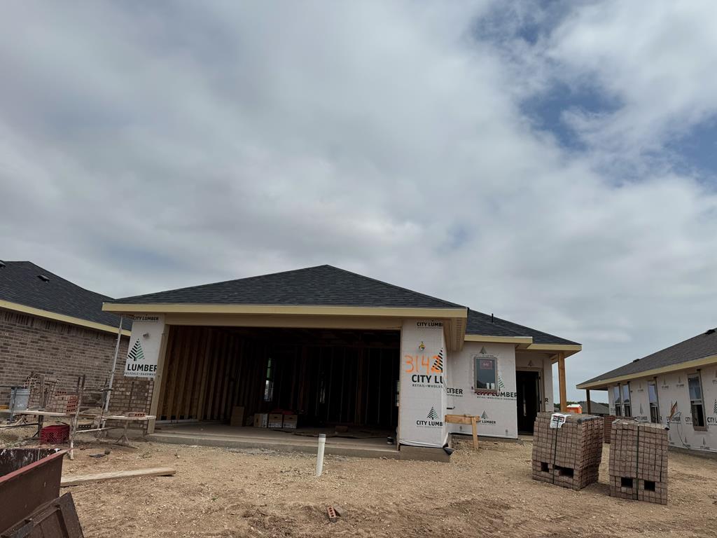 3142 Forest Hill Dr, San Angelo, TX 76904 - rear view of property featuring an attached garage and roof with shingles