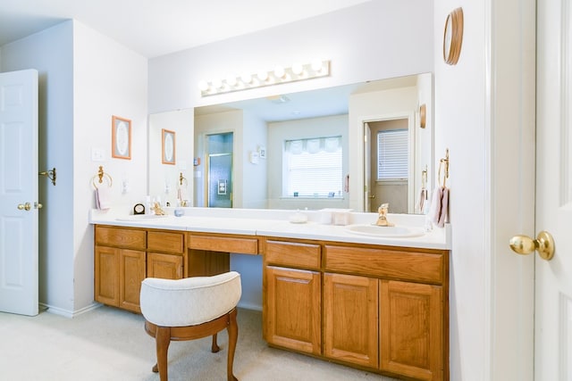 full bath featuring a sink, an enclosed shower, and double vanity