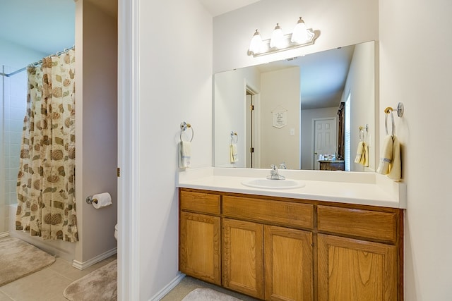 bathroom featuring tile patterned floors, toilet, shower / bath combo with shower curtain, and vanity