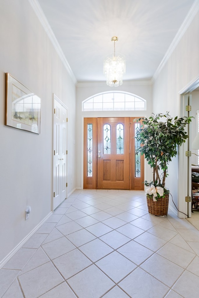 entryway featuring an inviting chandelier, light tile patterned floors, ornamental molding, and baseboards
