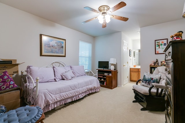 bedroom with connected bathroom, a ceiling fan, and light carpet