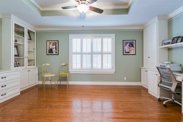 home office with ceiling fan, hardwood / wood-style flooring, ornamental molding, and built in shelves