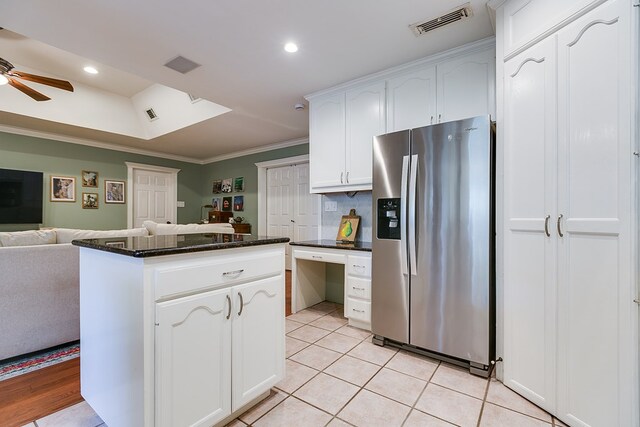 kitchen featuring light tile patterned flooring, ornamental molding, stainless steel fridge, ceiling fan, and white cabinets