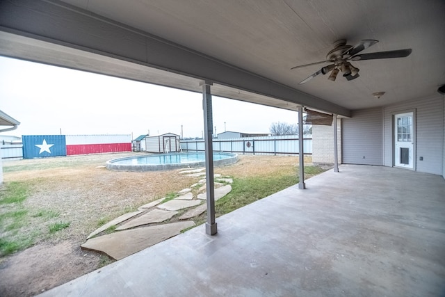 view of patio / terrace with a storage shed, a ceiling fan, a fenced in pool, a fenced backyard, and an outdoor structure