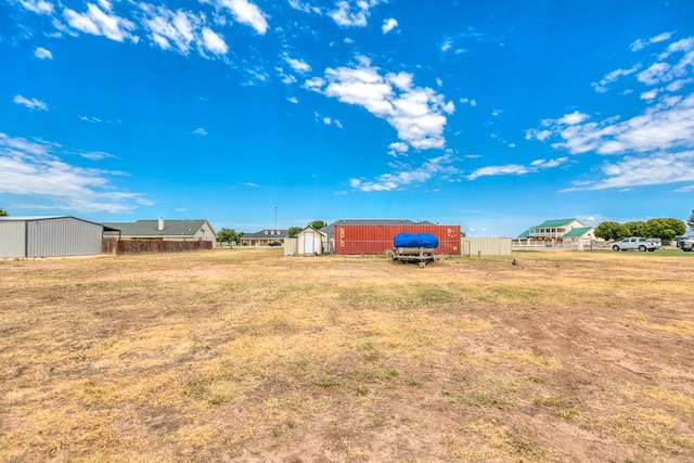 view of yard featuring an outbuilding, a pole building, and a storage shed