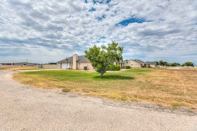 view of side of home with a garage, driveway, and a yard