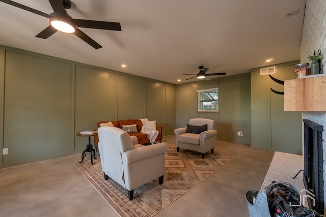 carpeted living room with a brick fireplace and ceiling fan