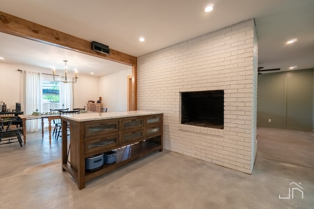 kitchen featuring beamed ceiling, decorative light fixtures, an inviting chandelier, and a brick fireplace