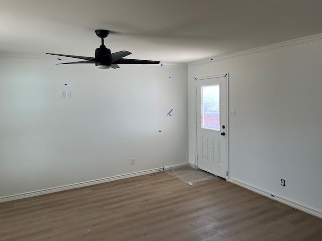 empty room with ceiling fan, ornamental molding, and wood-type flooring