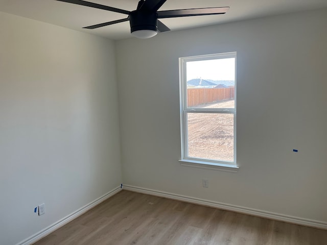 spare room with ceiling fan, a mountain view, and light wood-type flooring