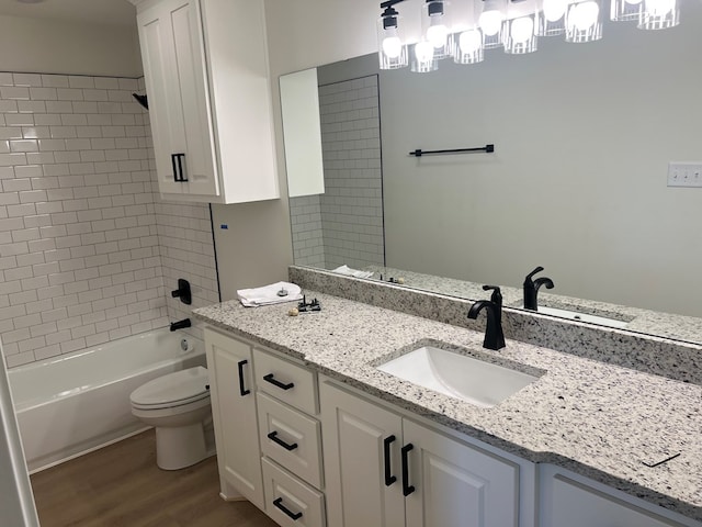 full bathroom featuring vanity, toilet, tiled shower / bath combo, and hardwood / wood-style floors