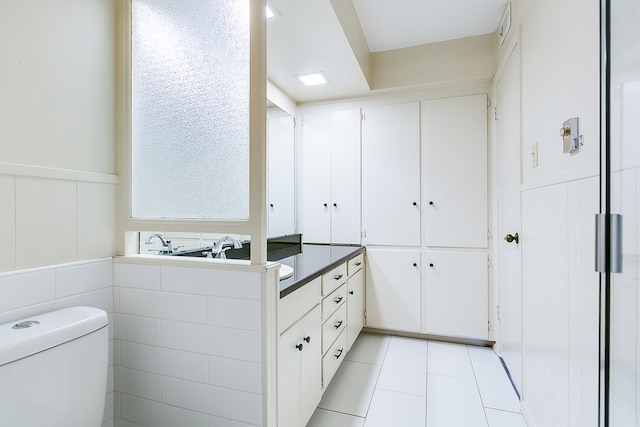 2472-D University Ave, San Angelo, TX 76904 - bathroom with tile patterned flooring, toilet, vanity, and a wainscoted wall