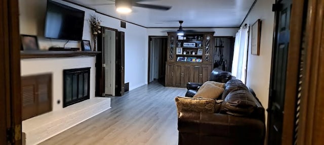 living room featuring a glass covered fireplace and wood finished floors