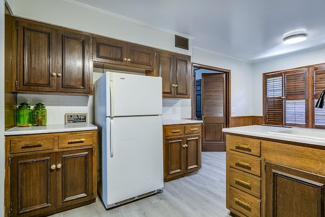 2671 Oxford Ave, San Angelo, TX 76904 - kitchen featuring freestanding refrigerator, a sink, crown molding, light wood-style floors, and light countertops