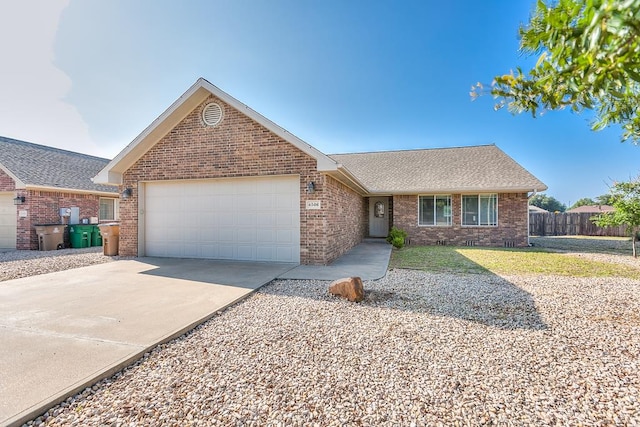 ranch-style house with roof with shingles, brick siding, fence, a garage, and driveway