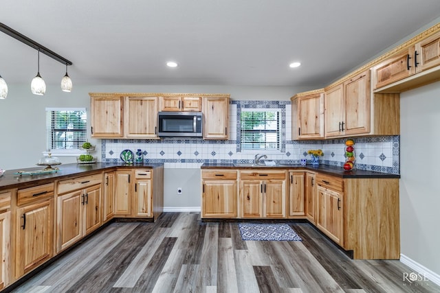 kitchen with hanging light fixtures, plenty of natural light, sink, and dark hardwood / wood-style flooring