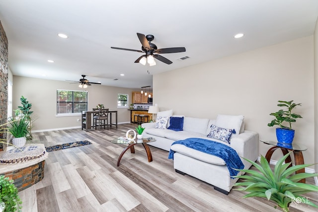 living room with light hardwood / wood-style floors and ceiling fan