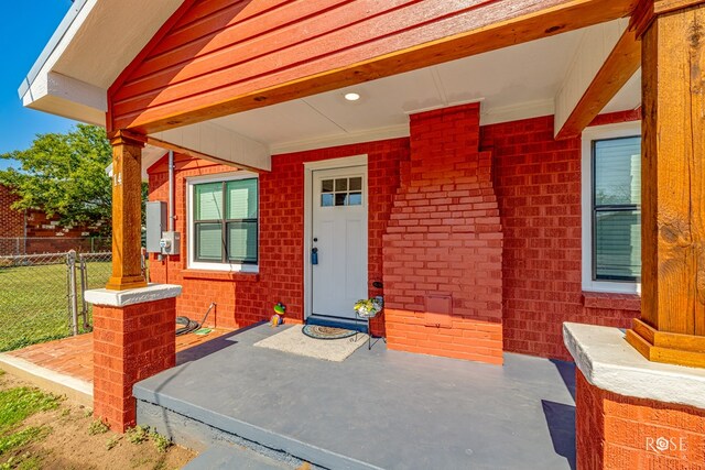 view of exterior entry featuring covered porch