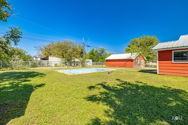 view of yard featuring a fenced in pool and a storage shed