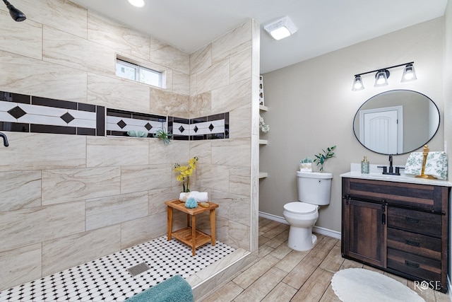 bathroom with vanity, toilet, and a tile shower