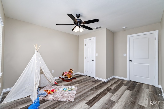 game room featuring dark hardwood / wood-style floors and ceiling fan