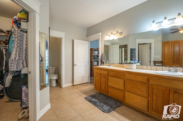 bathroom featuring ceiling fan, vanity, toilet, and tile patterned flooring