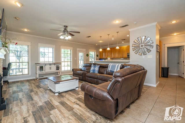 tiled living room featuring ceiling fan, ornamental molding, and a healthy amount of sunlight